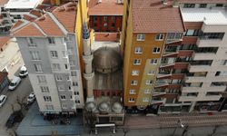 İki binanın arasında kalan cami ilginç görüntü oluşturuyor